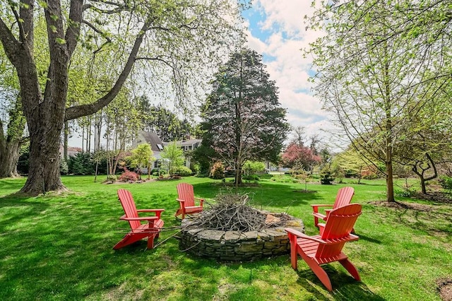 view of grassy yard with a fire pit