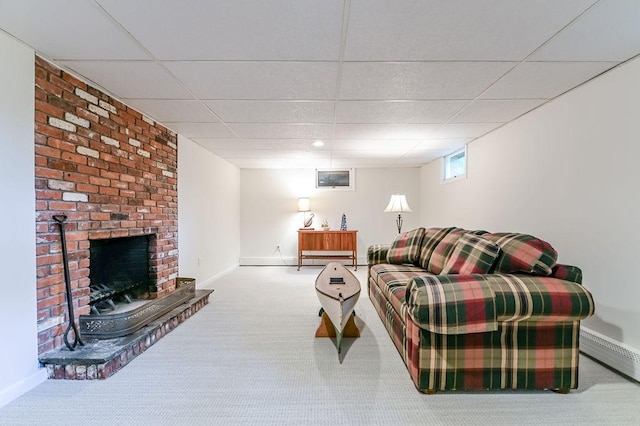 carpeted living area featuring a paneled ceiling, a brick fireplace, baseboards, and a baseboard radiator