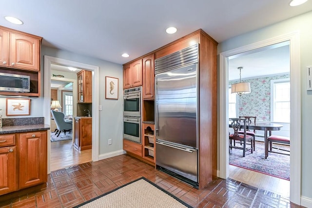 kitchen with stainless steel appliances, healthy amount of natural light, baseboards, recessed lighting, and wallpapered walls