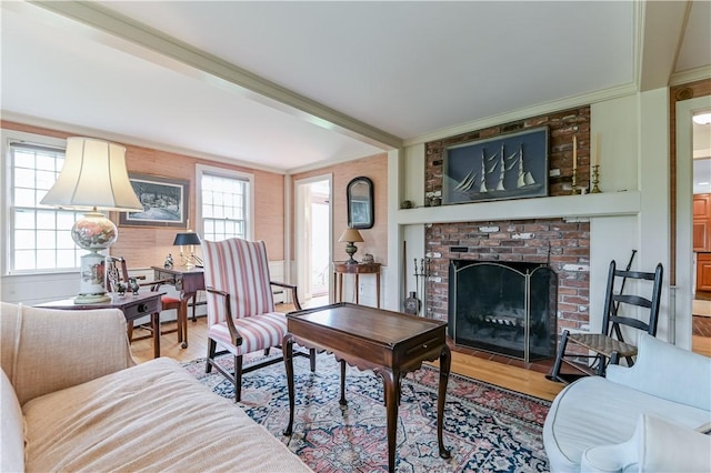 living room featuring wood finished floors, crown molding, and a fireplace