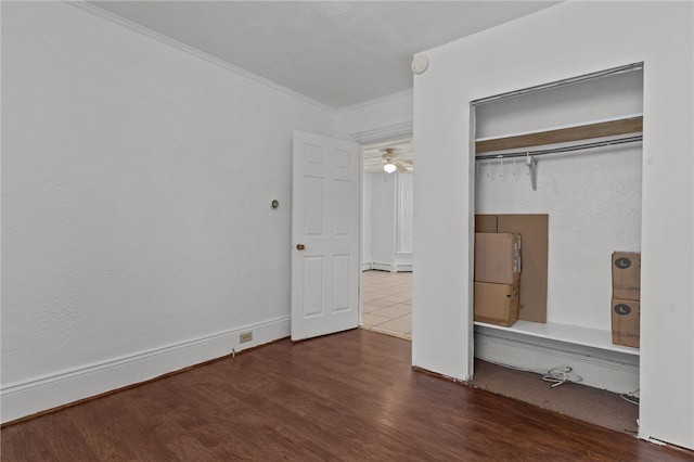 unfurnished bedroom featuring crown molding, wood finished floors, and a closet