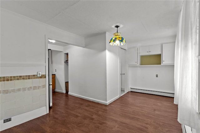 spare room featuring a baseboard radiator, dark wood-style floors, ornamental molding, and baseboards
