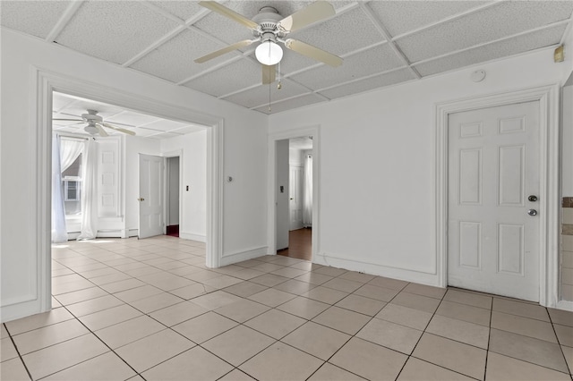 spare room featuring ceiling fan, light tile patterned flooring, and baseboards