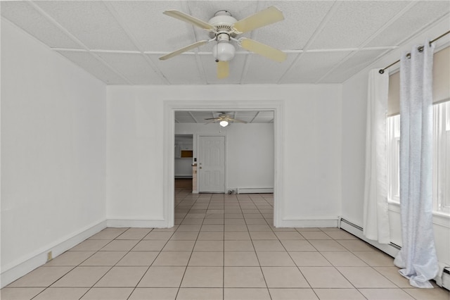 unfurnished room featuring ceiling fan, baseboard heating, light tile patterned floors, baseboards, and a baseboard heating unit