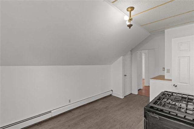additional living space featuring a baseboard radiator, vaulted ceiling, wood finished floors, and baseboards