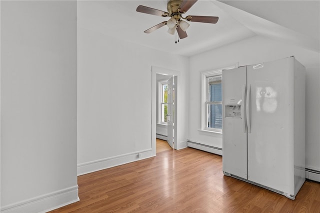 empty room with baseboard heating, a ceiling fan, and wood finished floors