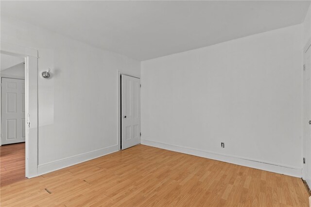 spare room with light wood-style floors and baseboards