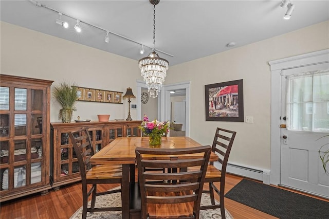 275 Hope St, Bristol, RI 02809 - dining space featuring rail lighting, a baseboard heating unit, wood finished floors, and a chandelier