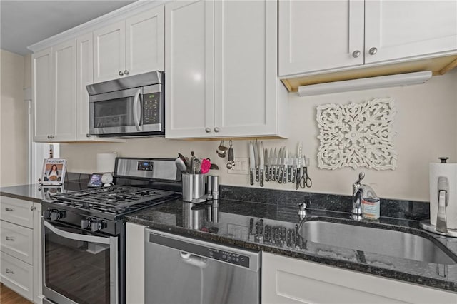 275 Hope St, Bristol, RI 02809 - kitchen with appliances with stainless steel finishes, white cabinetry, dark stone counters, and a sink