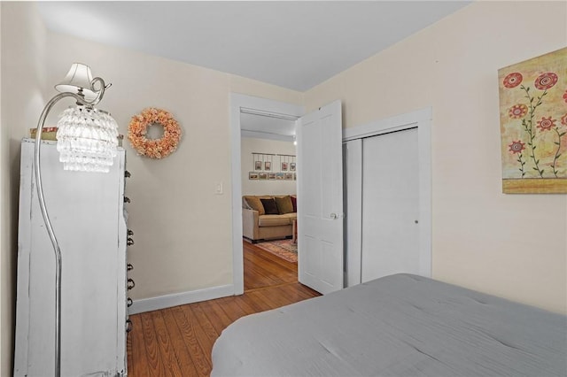 275 Hope St, Bristol, RI 02809 - bedroom with wood finished floors, baseboards, a closet, and a chandelier