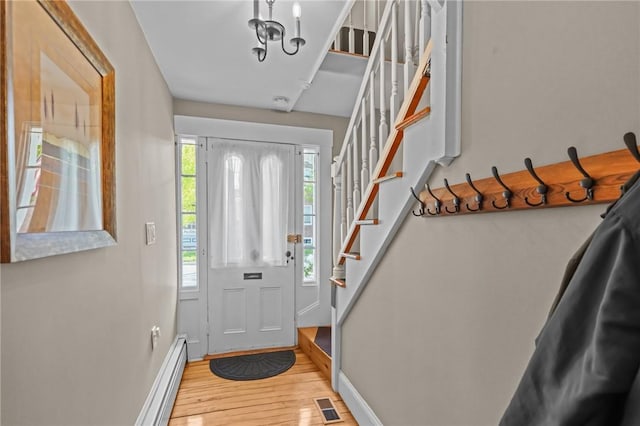 275 Hope St, Bristol, RI 02809 - entrance foyer featuring baseboards, light wood finished floors, stairway, baseboard heating, and a chandelier