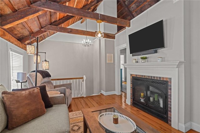 275 Hope St, Bristol, RI 02809 - living area with hardwood / wood-style floors, a glass covered fireplace, a chandelier, baseboards, and wooden ceiling