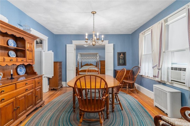 35 Miles Ave, East Providence, RI 02914 - dining room featuring a chandelier, light wood finished floors, radiator heating unit, baseboards, and cooling unit