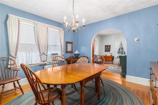 35 Miles Ave, East Providence, RI 02914 - dining room with arched walkways, a chandelier, light wood finished floors, and baseboards