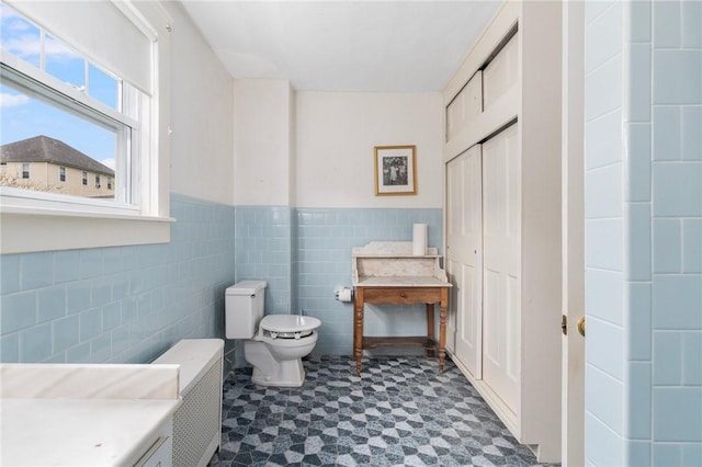 35 Miles Ave, East Providence, RI 02914 - bathroom featuring tile patterned floors, tile walls, toilet, and wainscoting