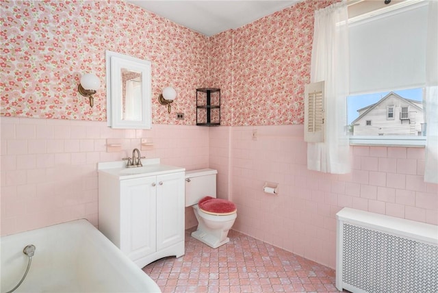 35 Miles Ave, East Providence, RI 02914 - bathroom with wallpapered walls, radiator, a wainscoted wall, a tub to relax in, and toilet
