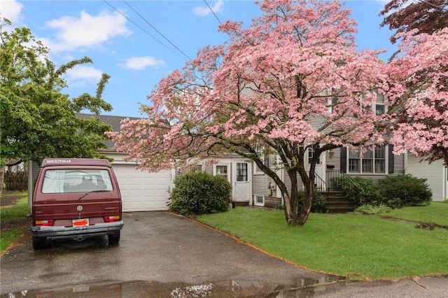 35 Miles Ave, East Providence, RI 02914 - view of property hidden behind natural elements featuring a front lawn, an attached garage, and asphalt driveway