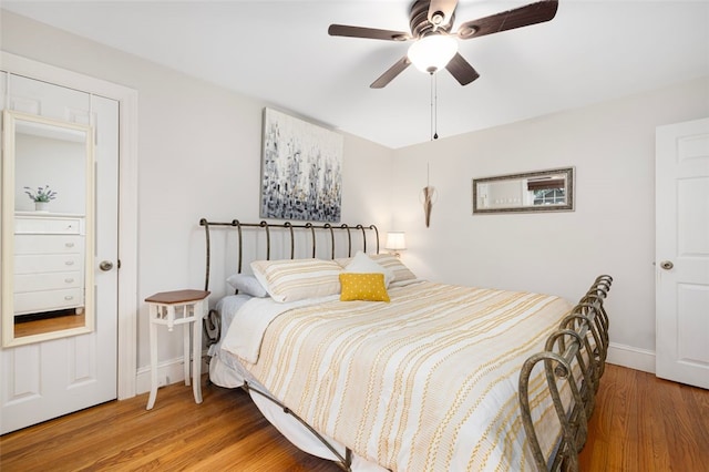 bedroom with wood finished floors, baseboards, and ceiling fan