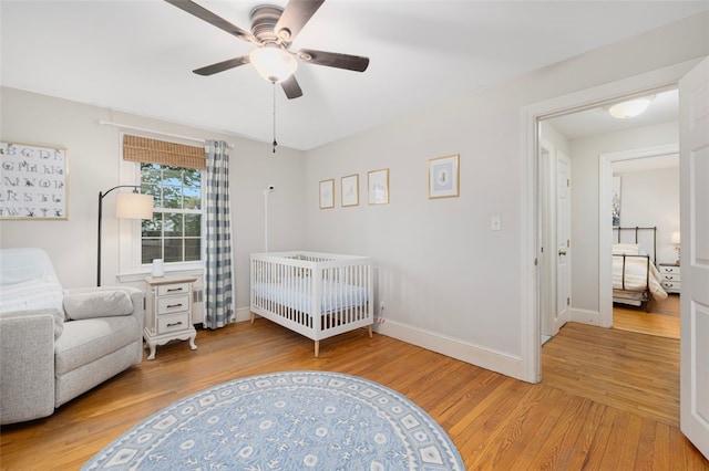 bedroom with wood finished floors, baseboards, and a ceiling fan