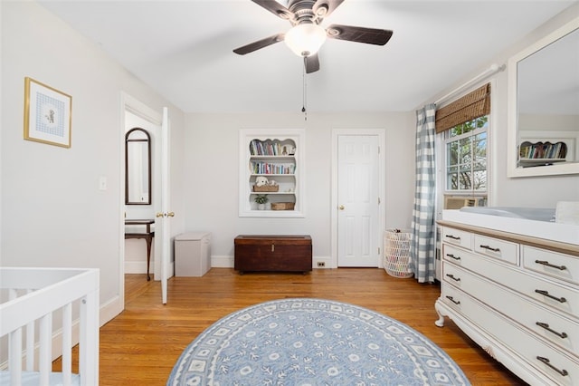 bedroom with light wood-type flooring, baseboards, and a ceiling fan