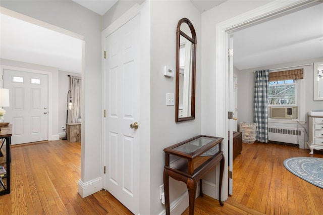 hall featuring radiator heating unit, hardwood / wood-style floors, cooling unit, and baseboards