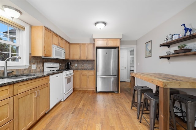 kitchen featuring white appliances, a sink, light wood finished floors, tasteful backsplash, and open shelves