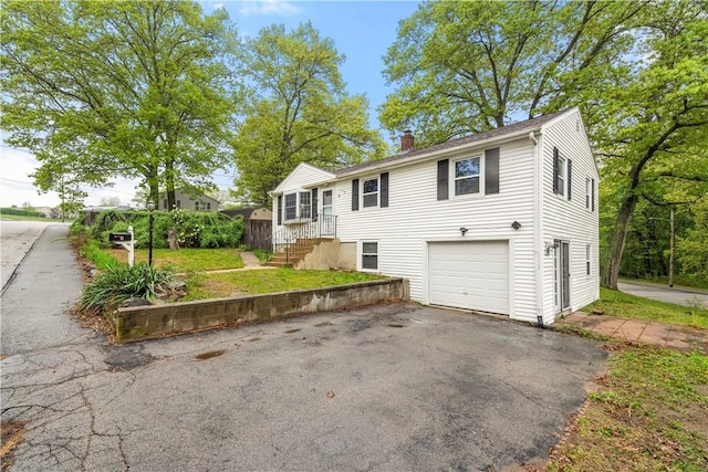 3 Baylor Dr, Coventry, RI 02816 - view of front facade featuring a chimney, asphalt driveway, a garage, and a front lawn