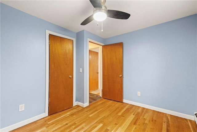 3 Baylor Dr, Coventry, RI 02816 - unfurnished bedroom featuring baseboards, light wood-type flooring, a closet, and a baseboard radiator