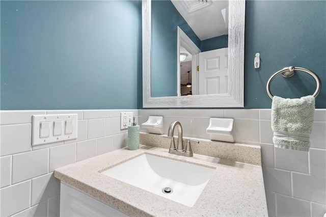 bathroom featuring tile walls, vanity, and a wainscoted wall