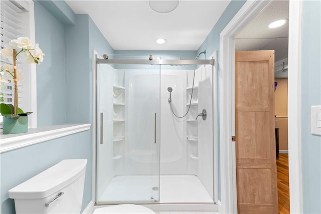 full bathroom featuring toilet, a shower stall, recessed lighting, and wood finished floors