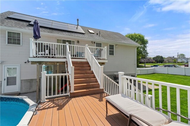 back of house featuring a deck, stairs, roof mounted solar panels, and a shingled roof