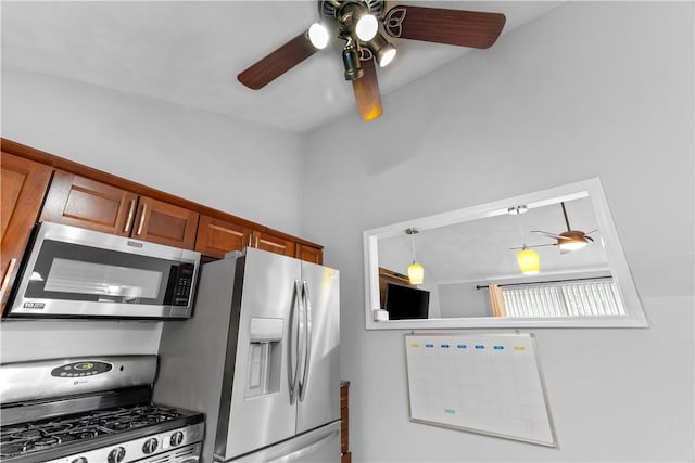 kitchen featuring appliances with stainless steel finishes, a ceiling fan, brown cabinetry, and hanging light fixtures