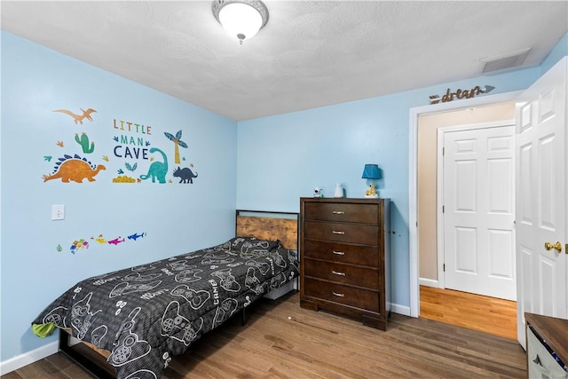 bedroom with wood finished floors and baseboards
