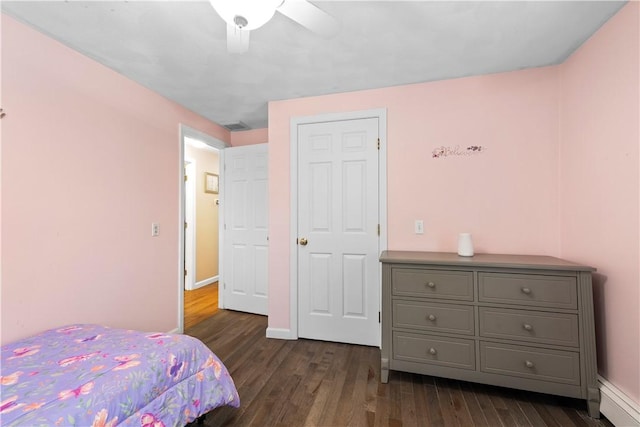 bedroom with dark wood-type flooring, a baseboard radiator, ceiling fan, and baseboards
