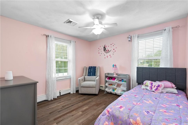 bedroom featuring wood finished floors, a ceiling fan, baseboard heating, and baseboards