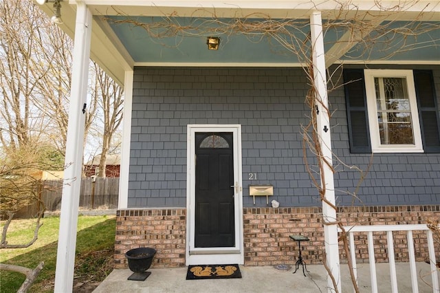 entrance to property featuring brick siding and a porch