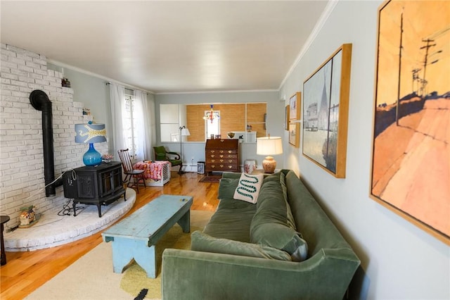 living area with a wood stove, wood finished floors, and ornamental molding