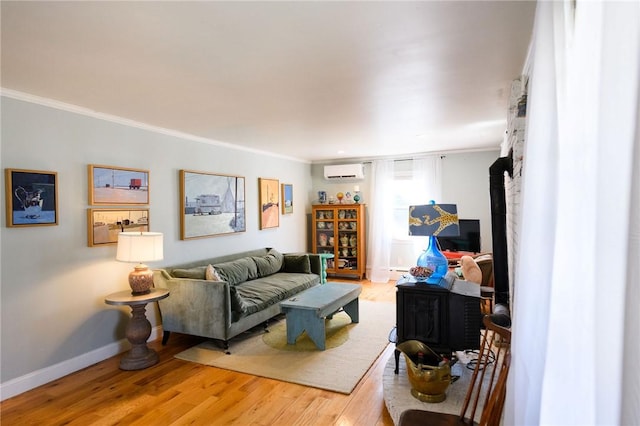 living room with a wall unit AC, crown molding, light wood-type flooring, and baseboards