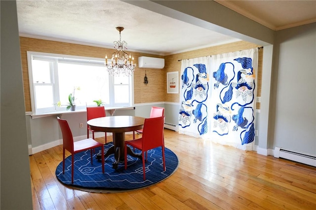 dining space with a wall mounted air conditioner, hardwood / wood-style floors, a baseboard heating unit, a chandelier, and baseboards