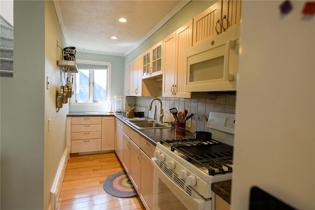 kitchen featuring white appliances, crown molding, a sink, decorative backsplash, and light wood-style floors