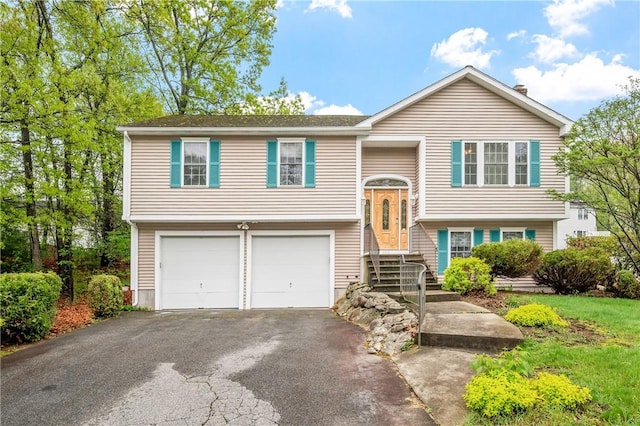 split foyer home with asphalt driveway and a garage
