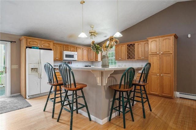 kitchen featuring white appliances, vaulted ceiling, light wood-type flooring, decorative backsplash, and light countertops