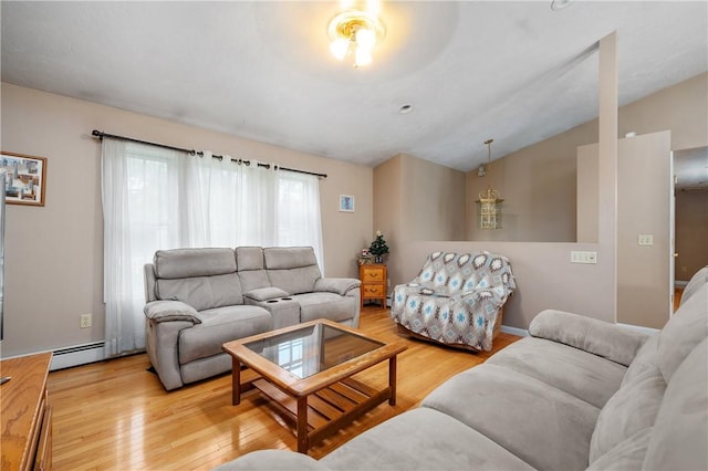 living area with a baseboard radiator, lofted ceiling, and light wood finished floors