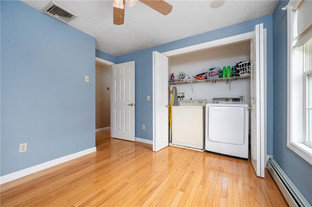 washroom featuring a baseboard radiator, independent washer and dryer, a ceiling fan, light wood finished floors, and baseboards