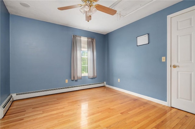 unfurnished room with attic access, a baseboard radiator, hardwood / wood-style flooring, and a ceiling fan