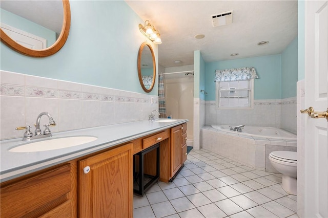 full bathroom featuring tiled tub, tile patterned floors, wainscoting, tiled shower, and tile walls