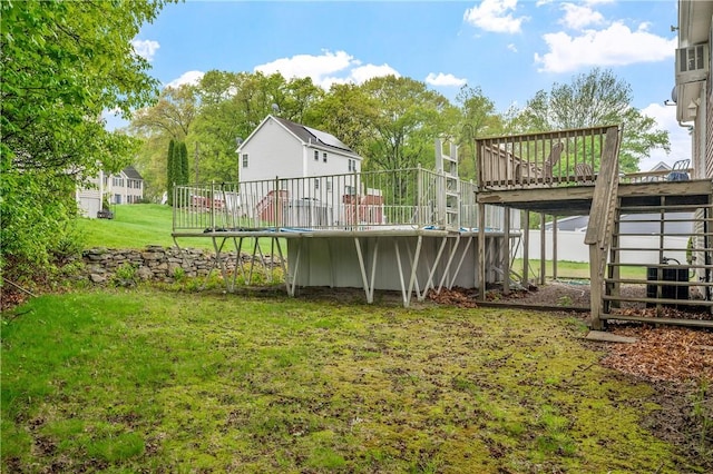 view of green lawn featuring a wooden deck and stairs