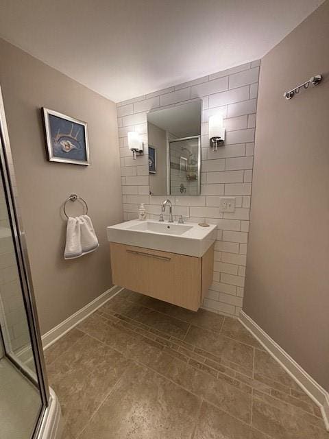 bathroom featuring a stall shower, vanity, tile patterned floors, tile walls, and baseboards