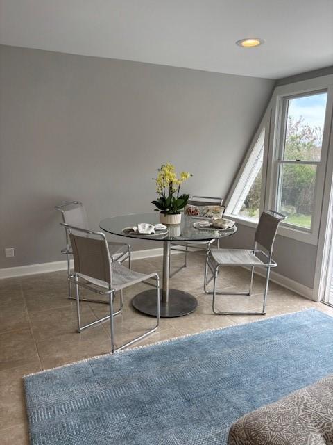 tiled dining space featuring baseboards and recessed lighting