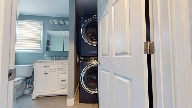 11 Crane St S, Pawtucket, RI 02860 - washroom with stacked washer and clothes dryer, light tile patterned flooring, and a sink
